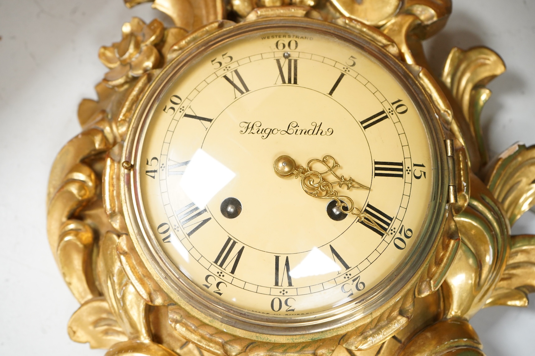 A Swedish giltwood rococo style cartel clock, convex enamel dial signed Hugo Lindh, Westerstrand, with key and pendulum, 56cm high